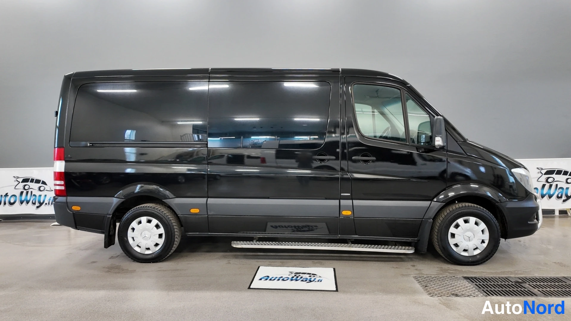 Sivulta: Mercedes-Benz Sprinter -pakettiauton sivuprofiili oikealta nähtynä sisätiloissa.