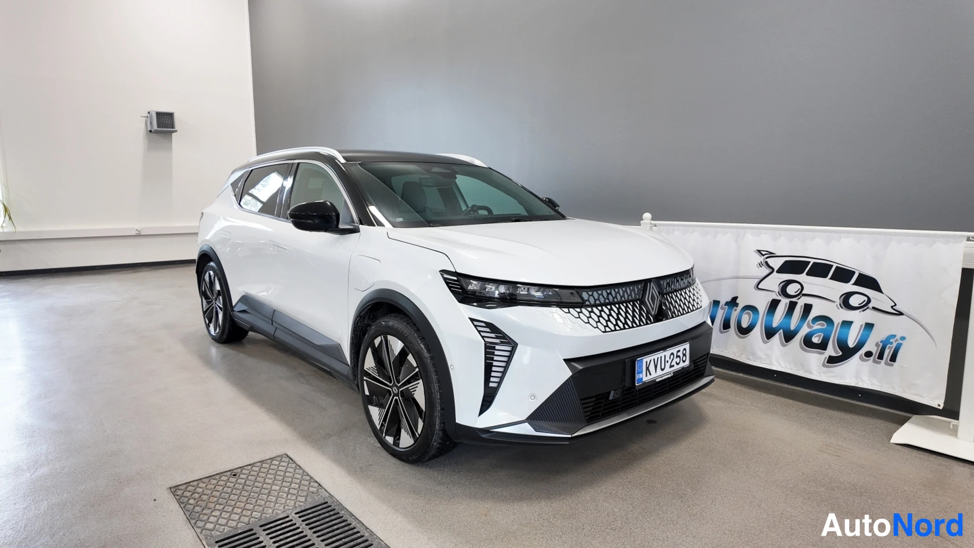 Etuviisto, nokka oikealle: Renault Scenic, valkoinen, etukulma vasemmalta sisätiloissa.