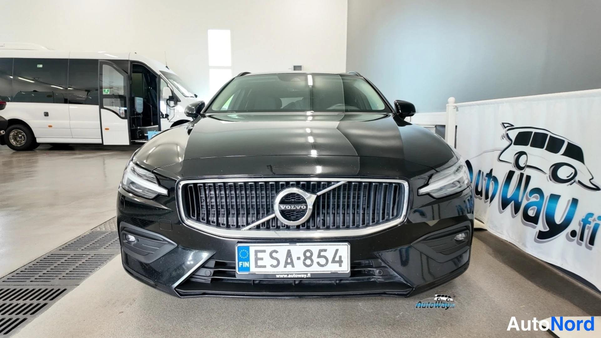 Edestä: Mustan Volvo V60:n etunäkymä, rekisteritunnus, AutoWay-hallissa.