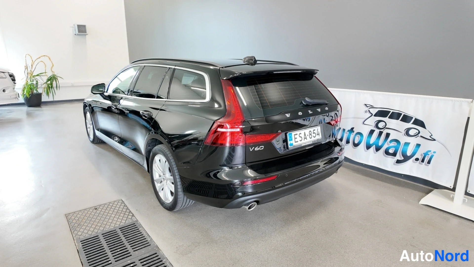 Takaviisto: Mustan Volvo V60:n takaolikolmannesnäkymä, rekisteritunnus.