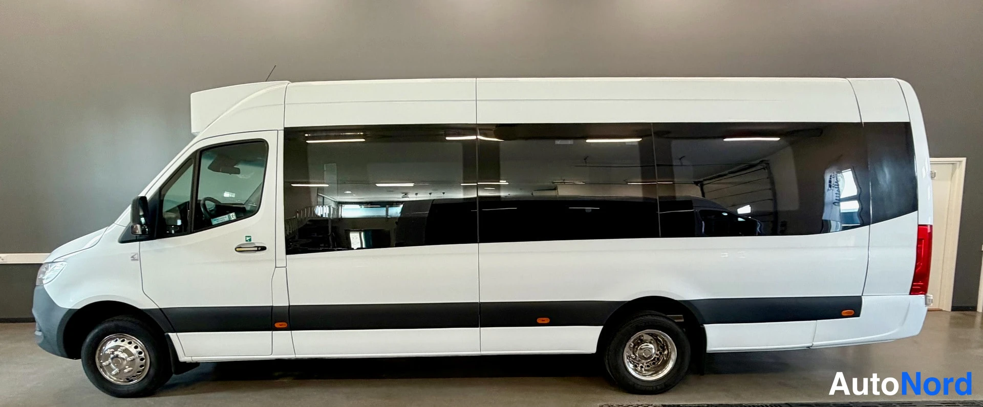 Sivulta: Mercedes-Benz Sprinter -pakettiauton sivuprofiili, valkoinen koritunnus tummilla ikkunoilla.