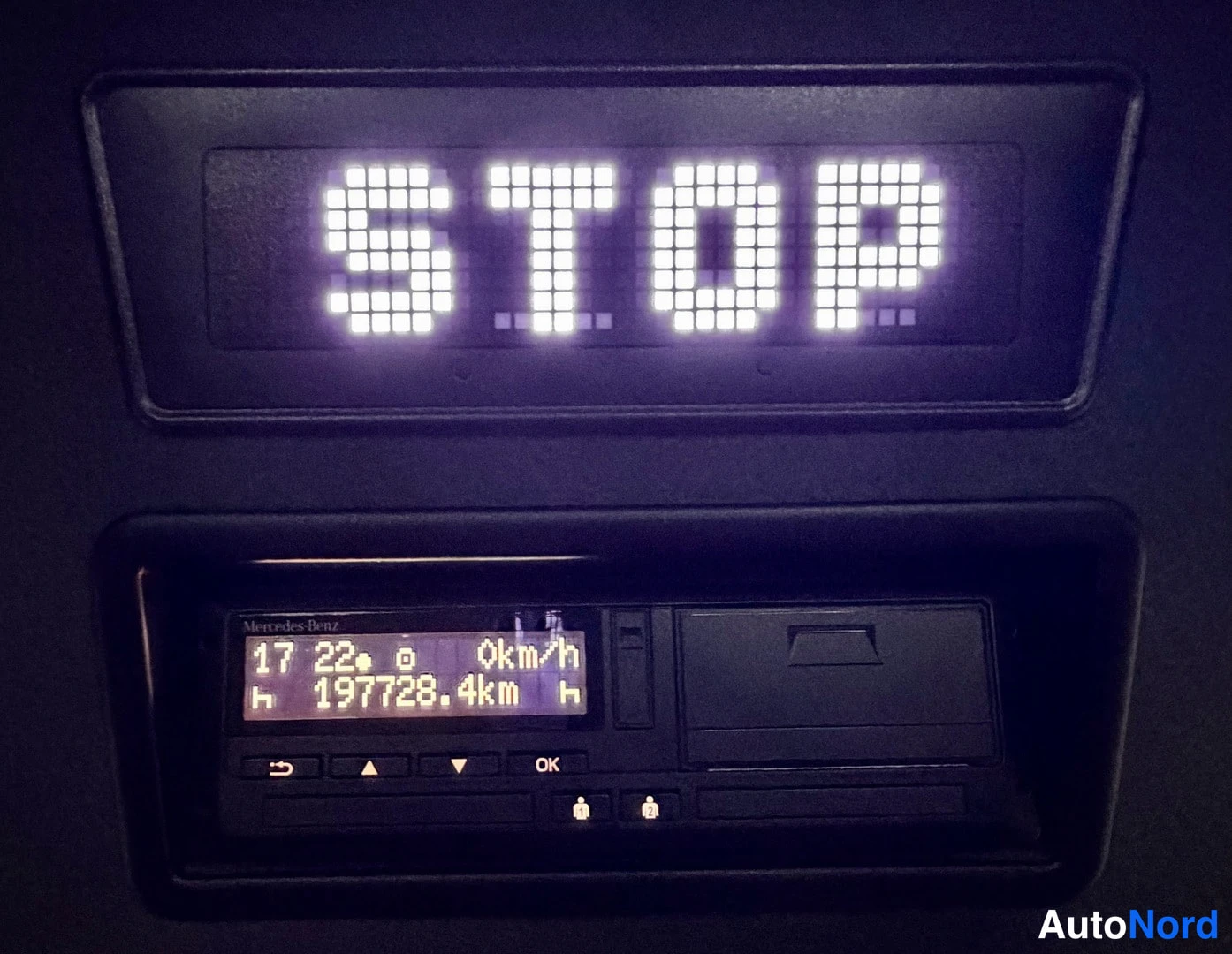 Yksityiskohta: Digitaalinen stop-näyttö ja ajokirjanpitolaite, jonka lukema näkyy 197728,4 km ja 0 km/h nopeudella.