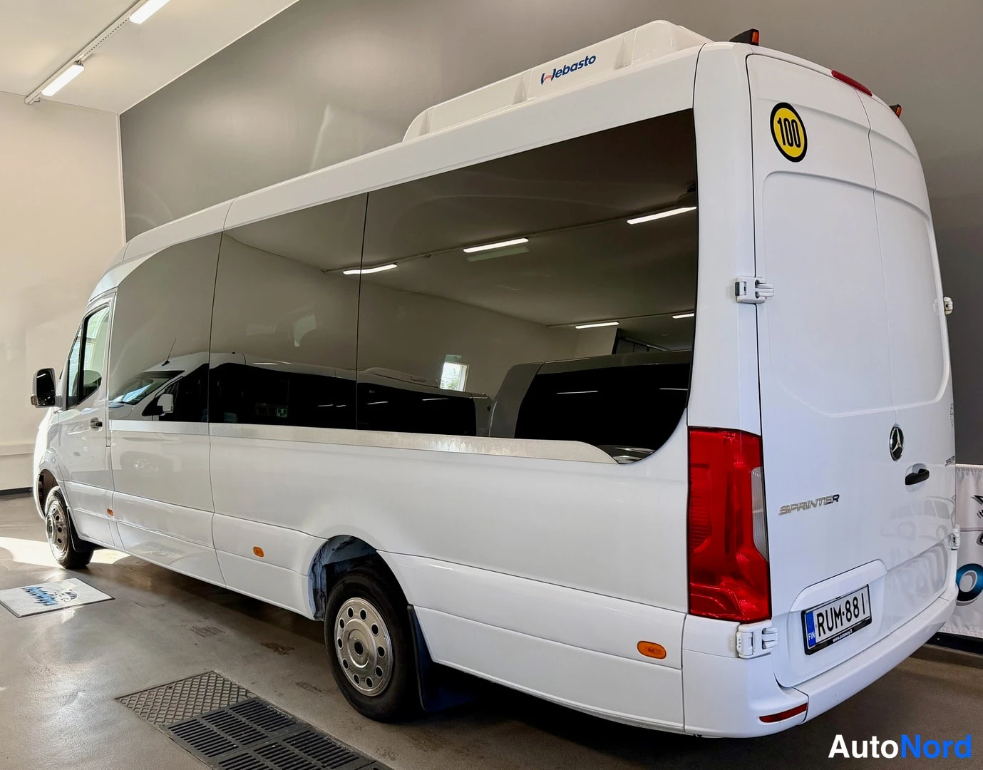 Takaviisto: Valkoinen Mercedes-pakettibusi kolmospaikalta takaa kuvattuna, tummat ikkunat ja rekisterikilpi.