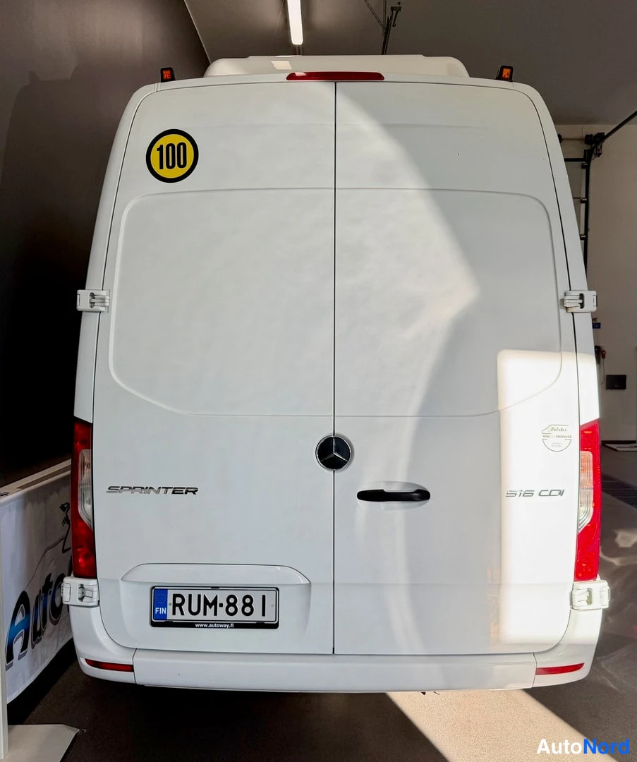 Takaa: Valkoisen Mercedes-Benz Sprinter -paketiauton takaosa: takaluukut, 'SPRINTER' ja '516 CDI' -tekstit, '100'-tarra ja -rekisterikilpi.