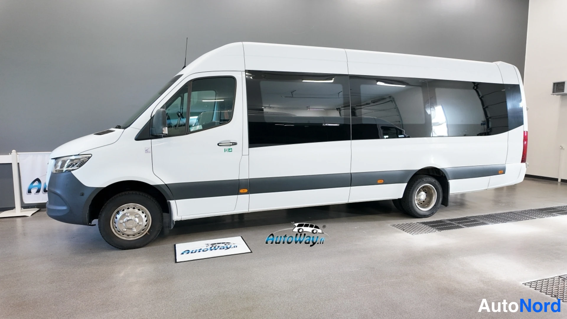 Etuviisto, nokka vasemmalle: Valkoinen Mercedes-Benz Sprinter -pakettiauto sivulta ja hieman edestä, nokka kuvan vasemmassa reunassa.