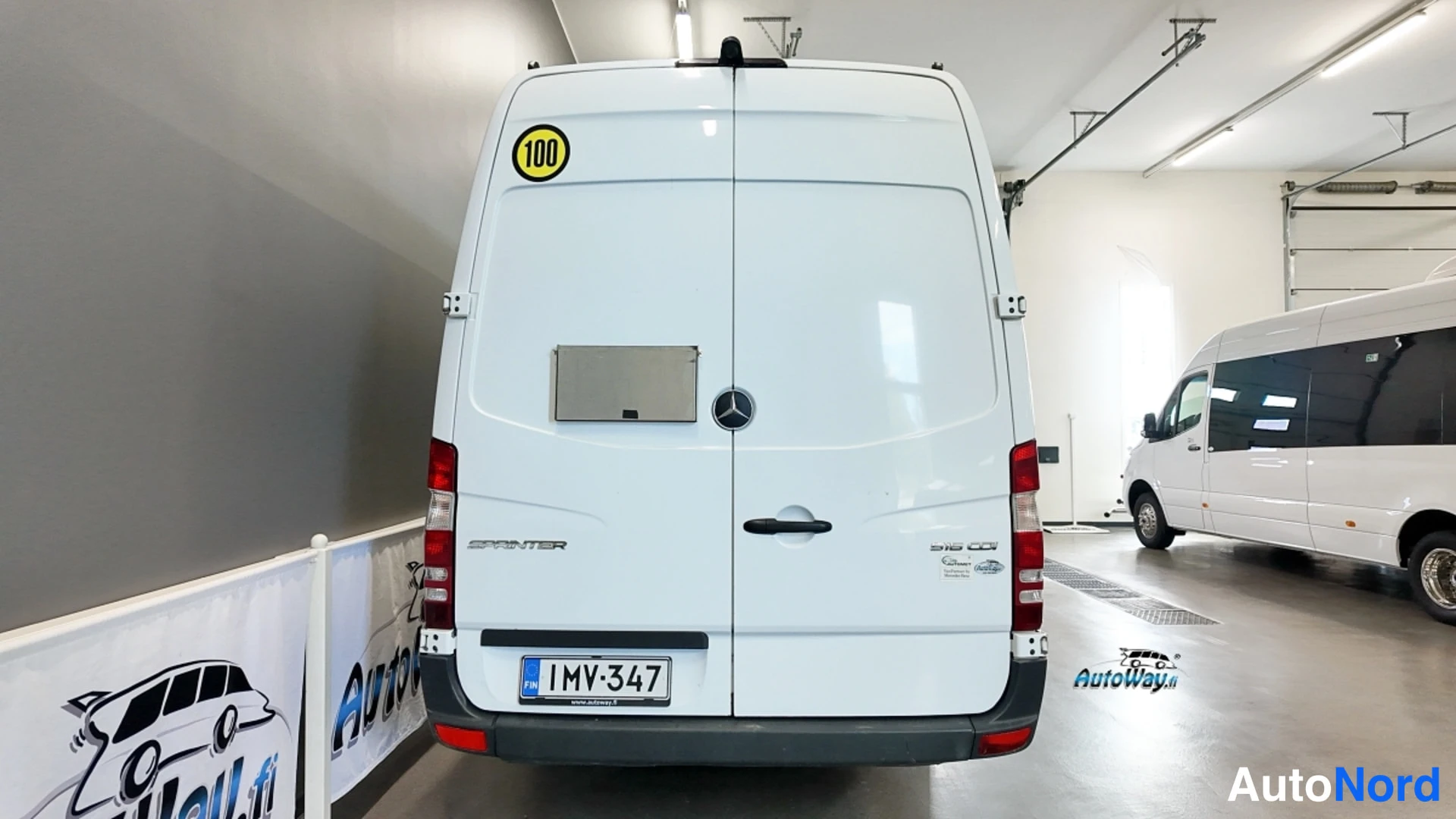 Takaa: Valkoisen Mercedes-Benz Sprinter -auton takaosa suoraan takaa, rekisterikilpi.