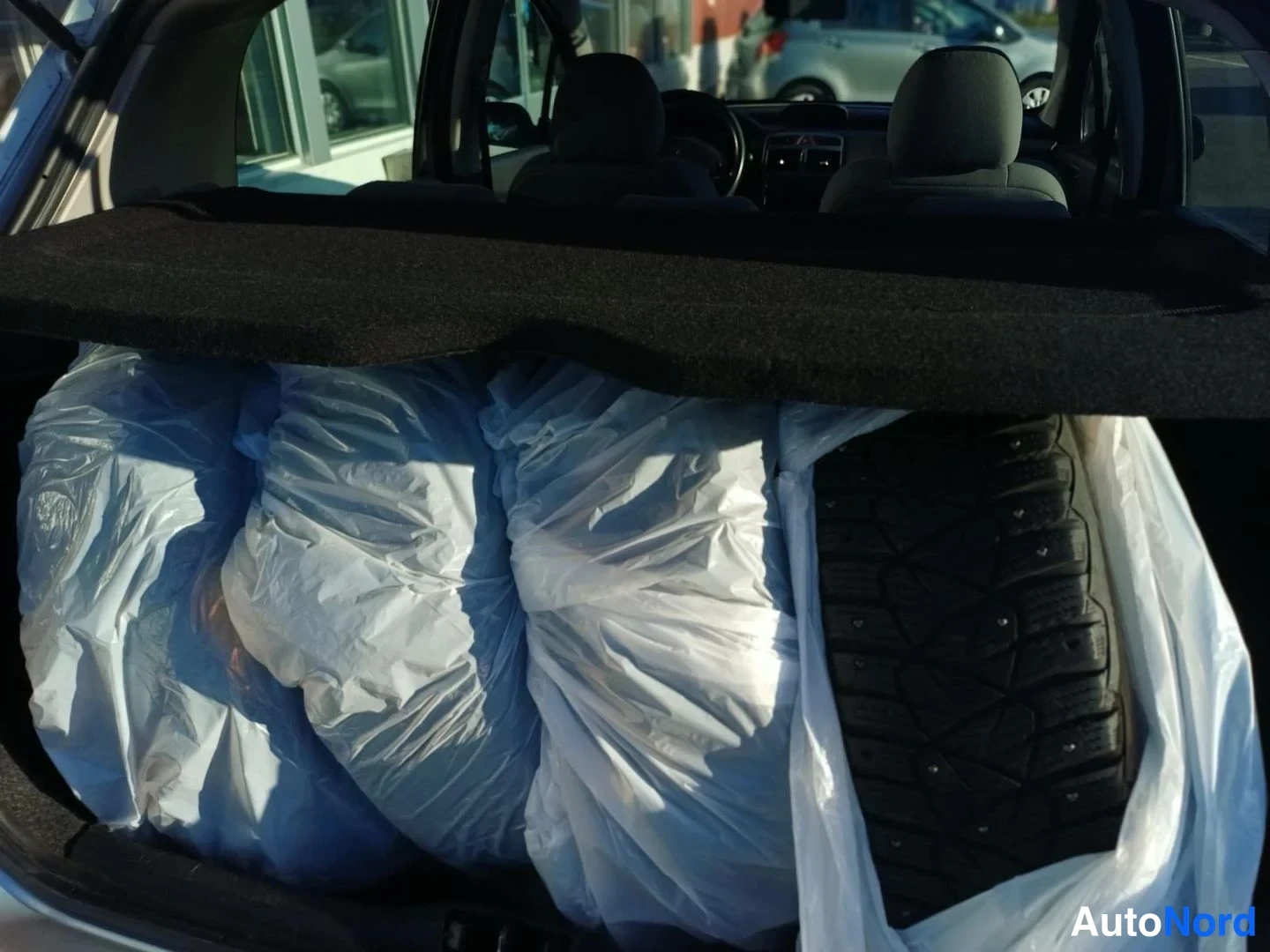 Muu: Peugeot 307:n tavaratila: neljä talvirenkaita muovipusseissa.