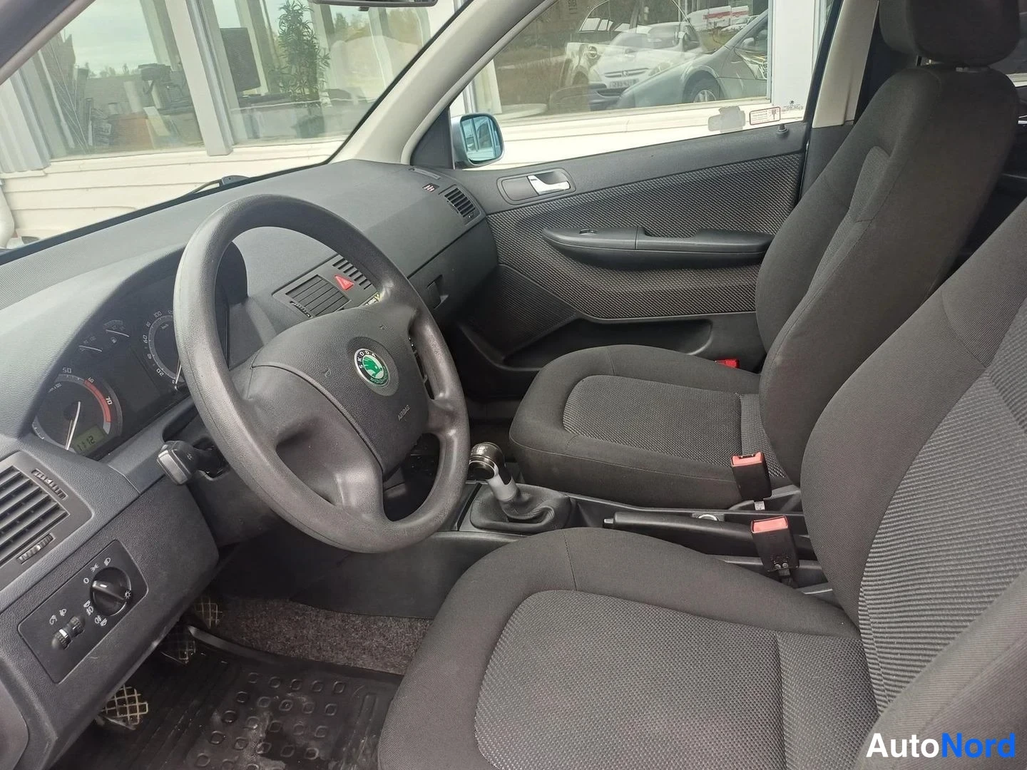 Muu: Auton ohjaamo vasemmalta: Skoda-merkkinen ohjauspyörä, kangasistuimet ja manuaalivaihteisto.