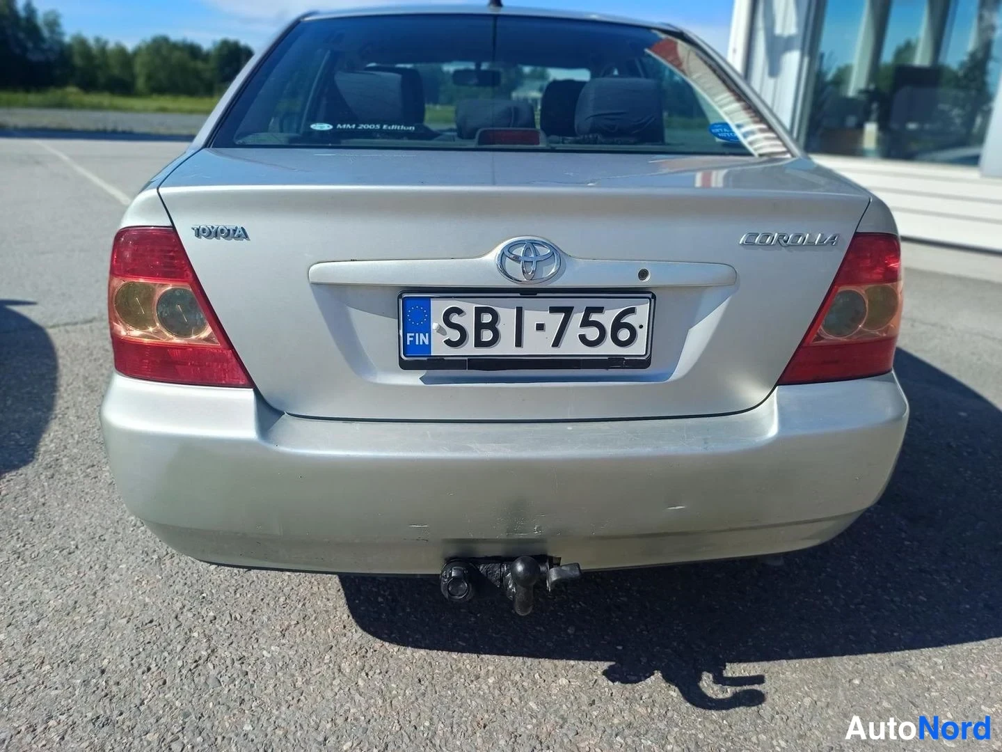 Takaa: Toyota Corollan takaosa suoraan takaa, rekisteritunnus ja irrotettava vetoaisa takapuskurin alla.