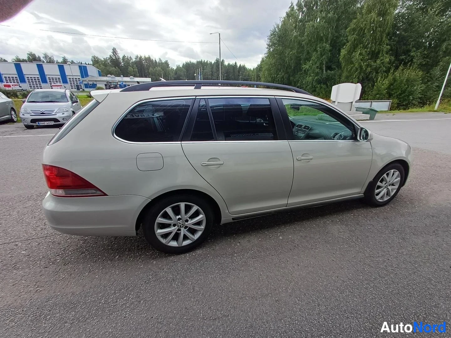 Takaviisto: Farmariauto takaviistosta kuvattuna, takavalo ja kylki näkyvät, kattokaiteet ja hopeanväriset vanteet.
