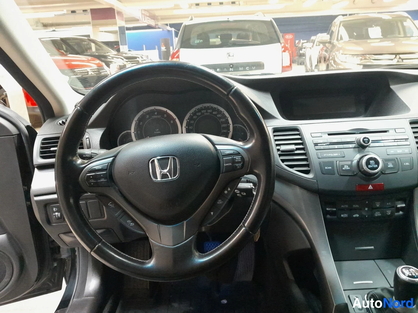 Sivulta: Honda Accordin ohjaamo vasemmalta: Honda-merkkinen ratto, mittaristo, käsiraatio ja keskikonsoli.radio.