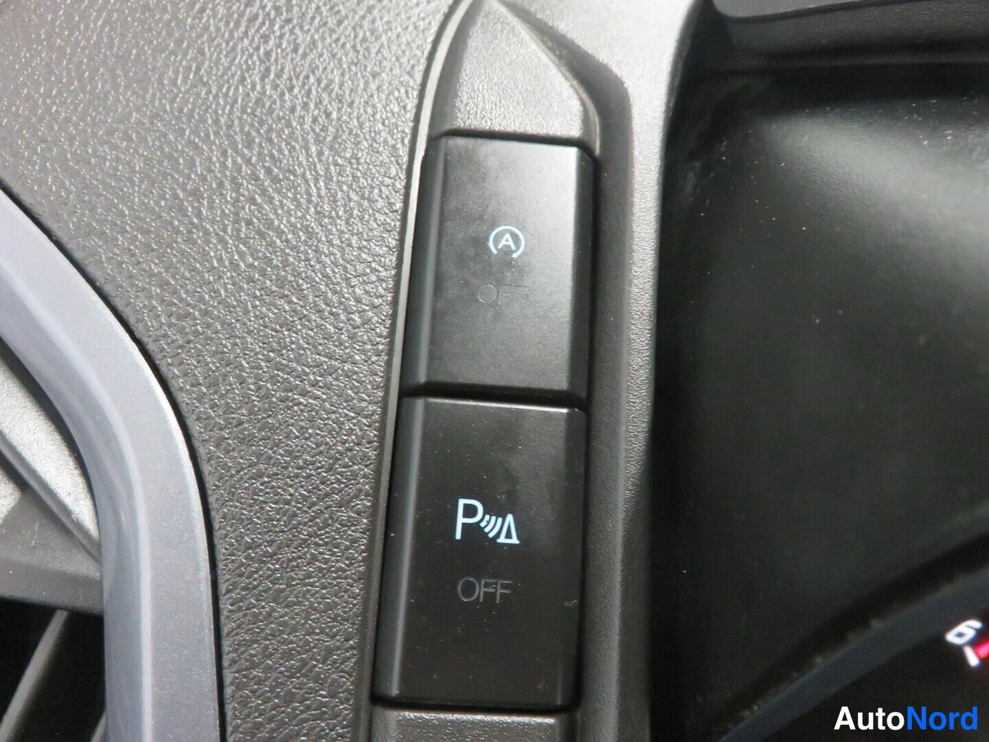 Yksityiskohta: Kojeiston painikkeet: auto start -stopin OFF-painike ja pysäköintitutkan OFF-painike (P- ja säteilykuvake).