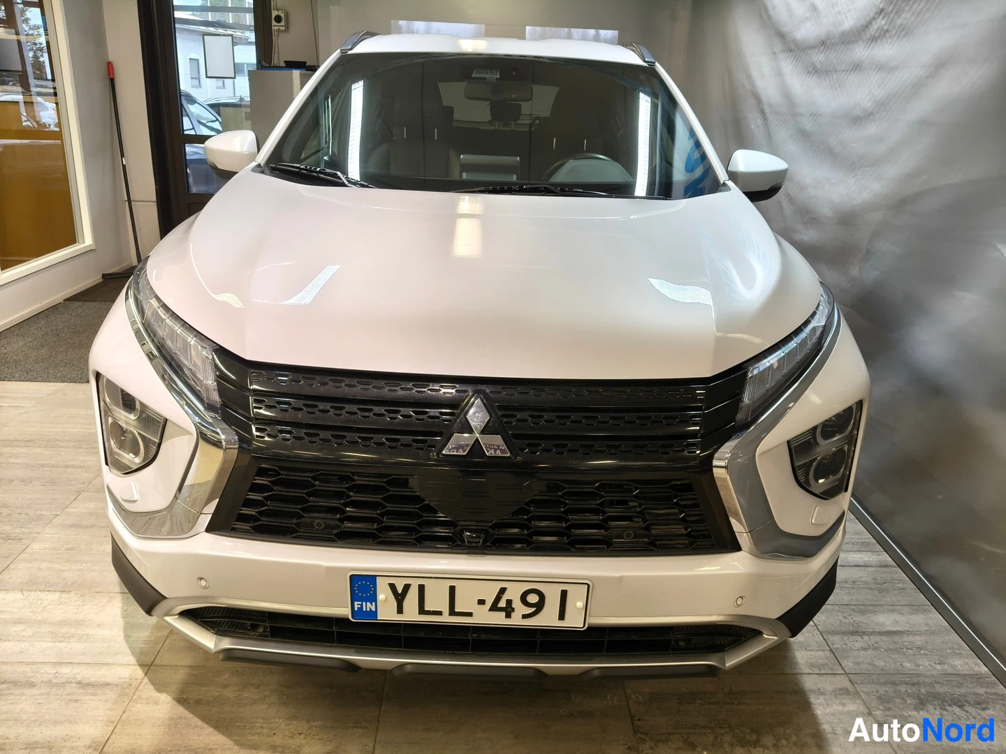 Edestä: Mitsubishi Eclipse Cross, valkoinen, suora etukuva; musta etusäleikkö ja Mitsubishi-tunnus, rekisterikilpi.