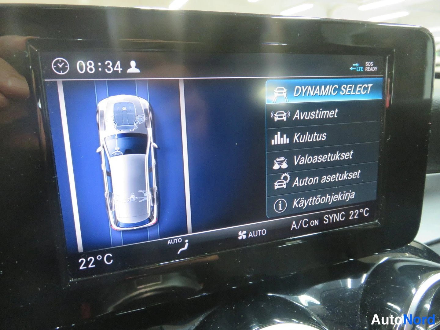 Muu: Auton näyttö DYNAMIC SELECT-valikolla: Avustimet, Kulutus, Valoasetukset, Auton asetukset, Käyttöohjekirja; vasemmalla ajoneuvon ylhäältäkuva.