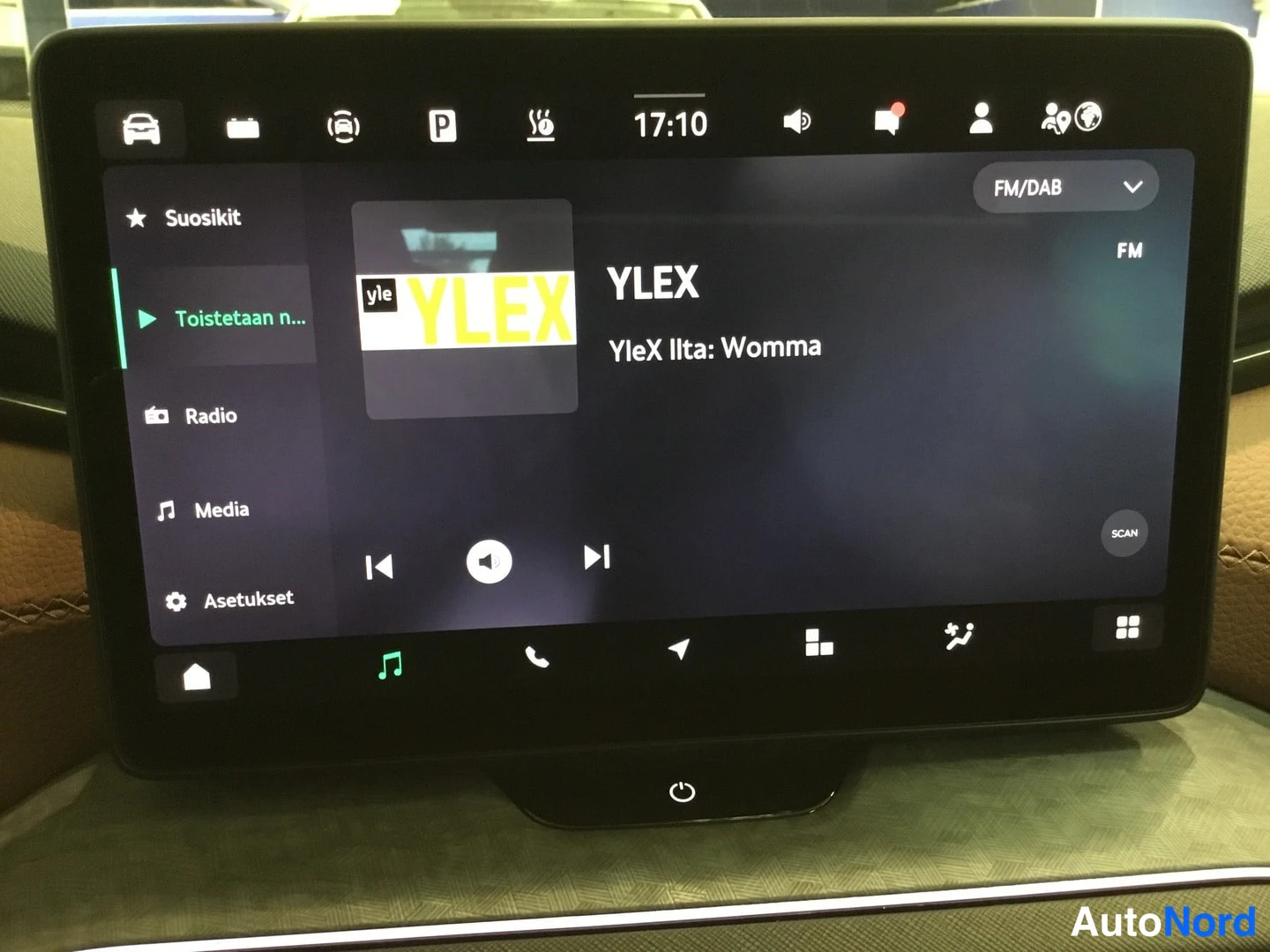 Muu: Auton keskinäyttö näyttää FM/DAB-radion: kanava YLEX, ohjelmassa YleX Ilta: Womma, kello 17:10; valikossa Suosikit, Radio, Media ja Asetukset.