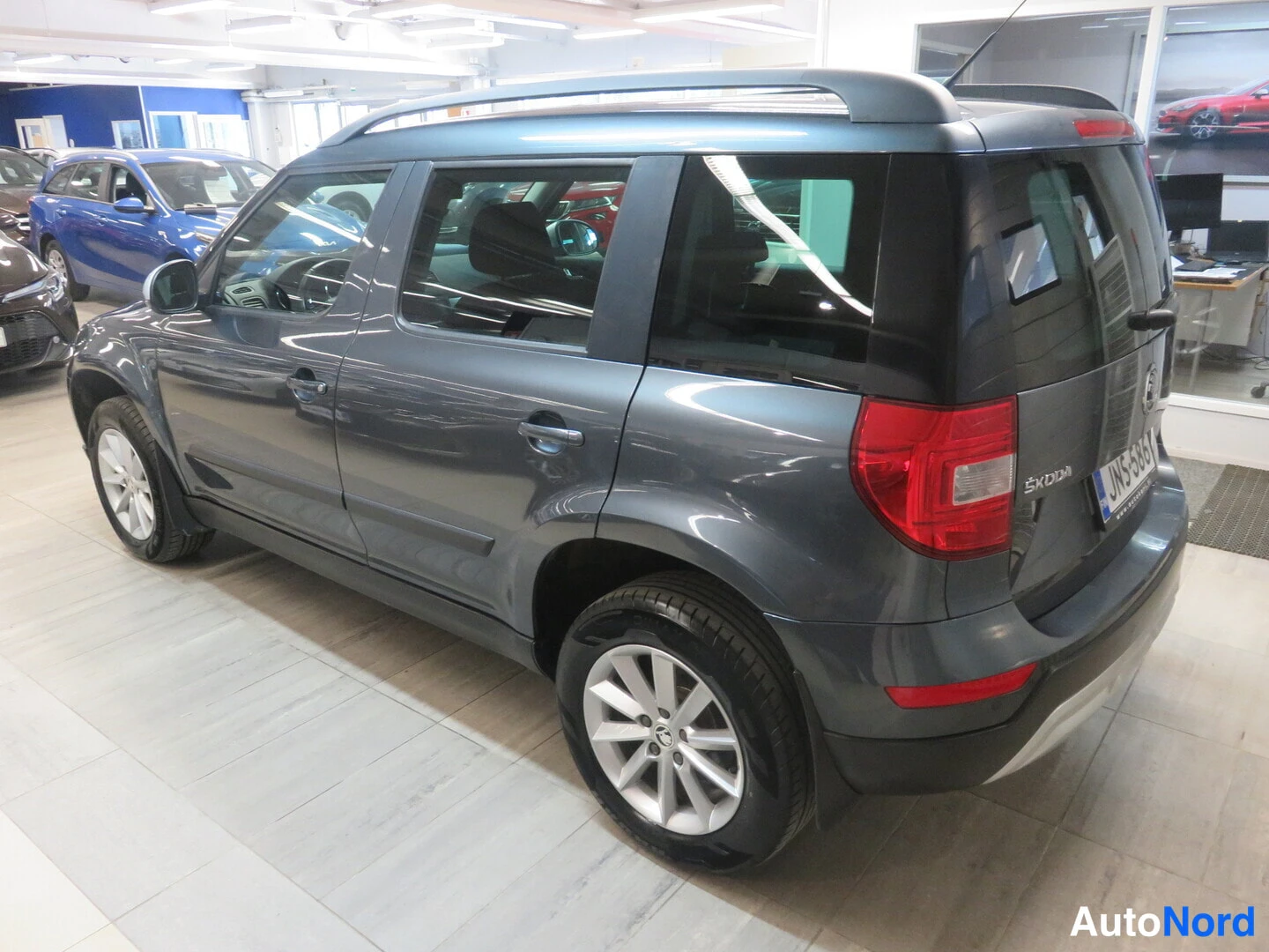 Takaviisto: Skoda Yeti, harmaa, takaosa ja kylki kolmannelta kulmasta sisätiloissa.