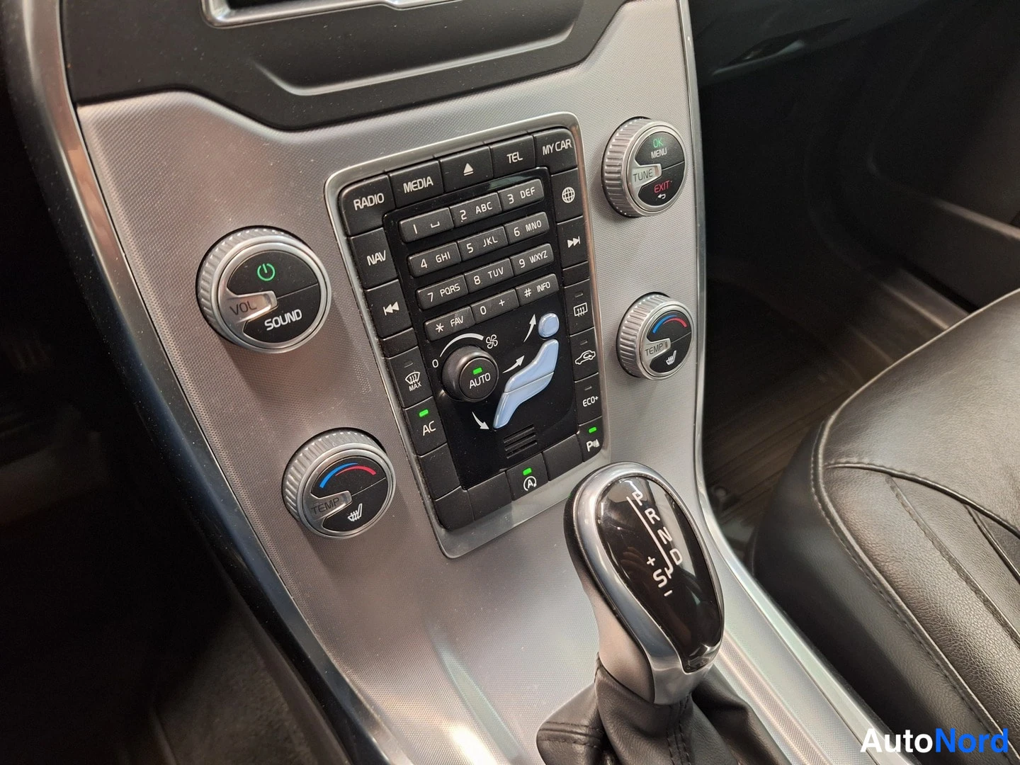 Yksityiskohta: Auton keskikäyttöpöytä radio- ja ilmastointinapeilla sekä automaattivaihteiston valitsin (P R N D S).