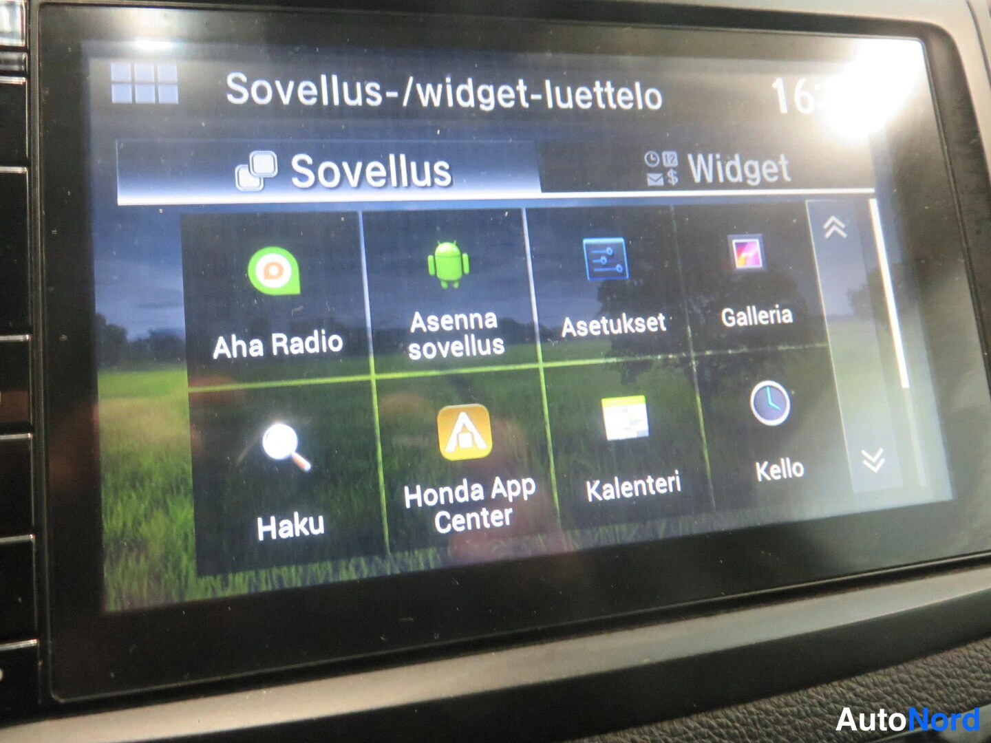 Yksityiskohta: Auton kosketusnäyttö, jossa sovellusluettelo: Aha Radio, Asenna sovellus, Asetukset, Galleria, Haku, Honda App Center, Kalenteri ja Kello.