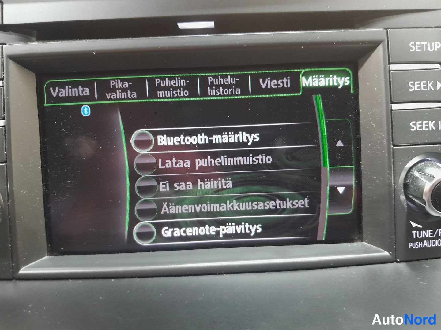 Muu: Auton viihdejärjestelmän näyttö puhelimen asetuksissa, korostettuna kohta Bluetooth-määritys