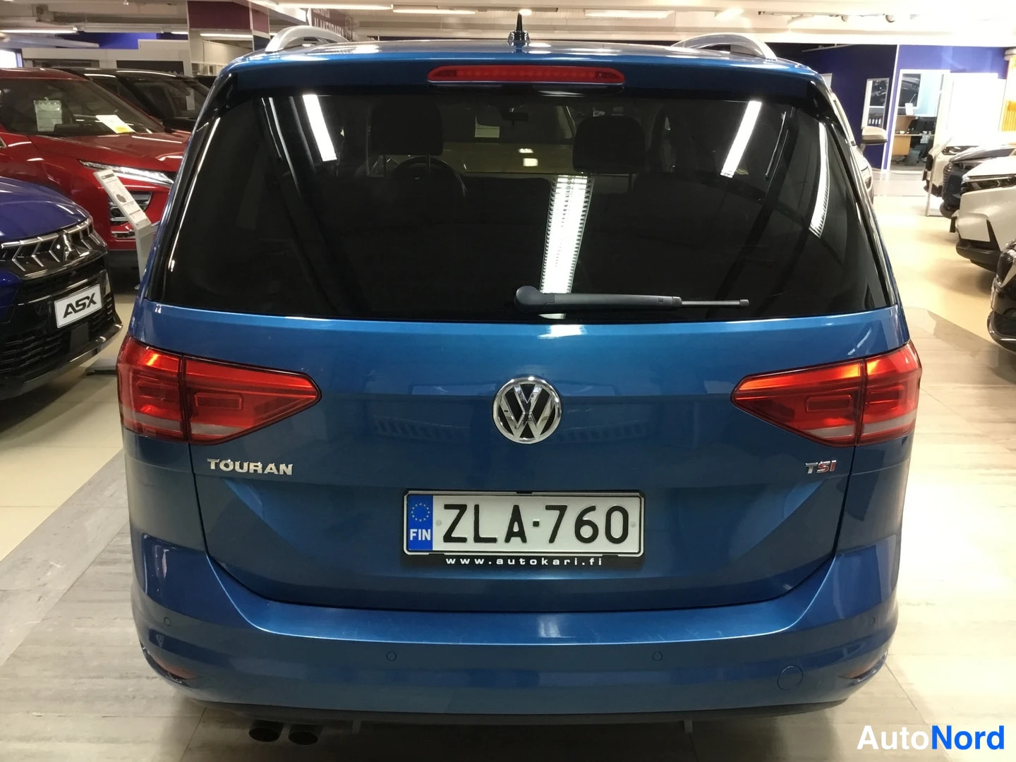 Takaa: Auton takaosa rekisteritunnus, tavaratilan luukku ja takavalot.