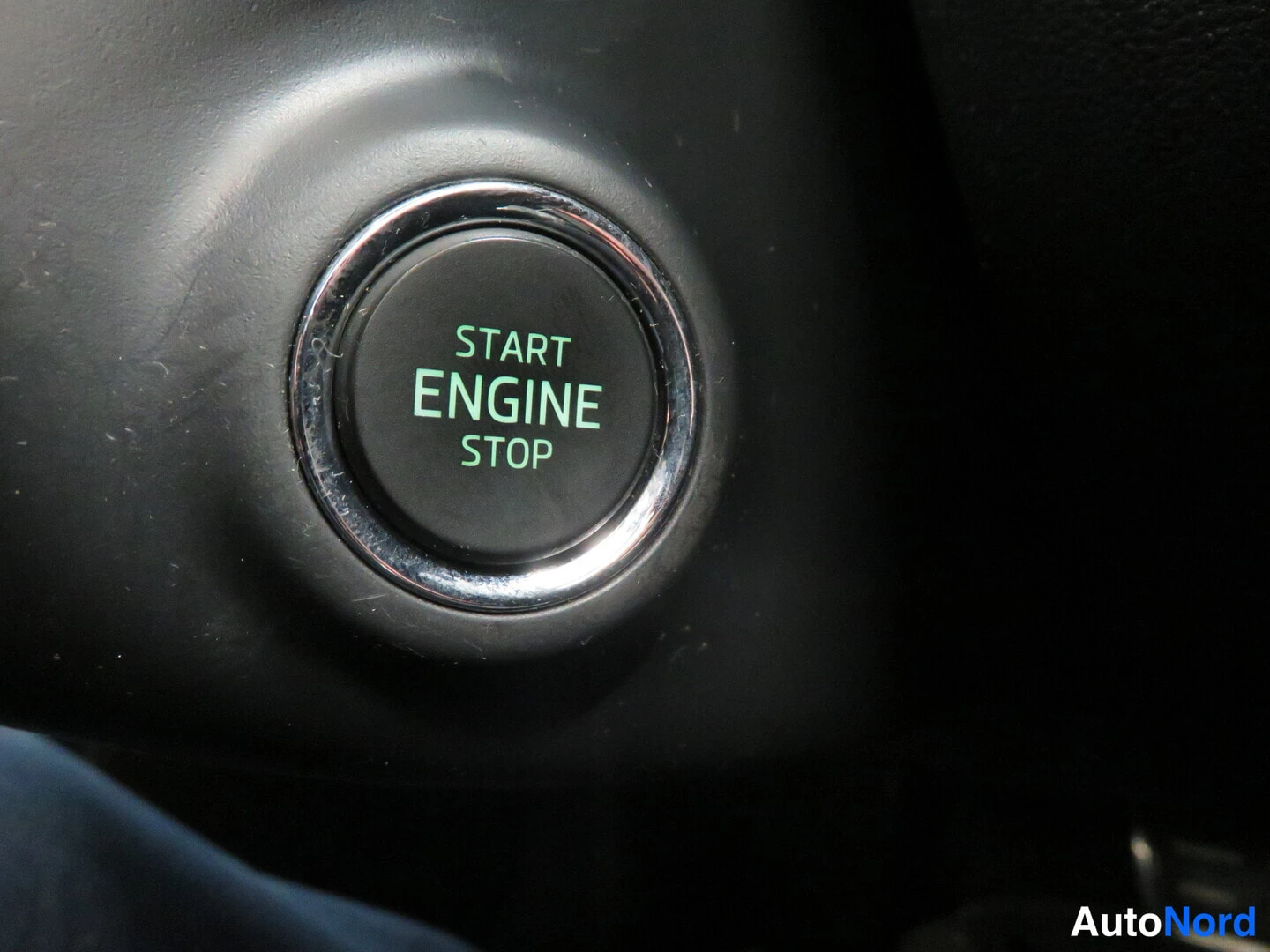 Yksityiskohta: Start Engine Stop -moottorin käynnistyspainike, musta pyöreä nappi kromireunuksella