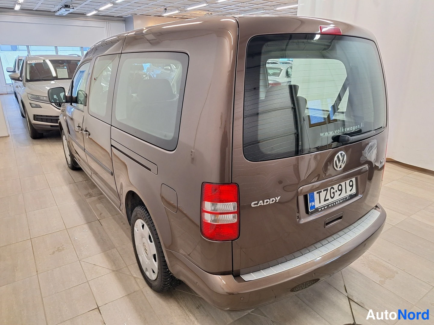 Takaviisto: Volkswagen Caddy, ruskea pakettiauto takakulmasta vasemmalle, CADDY-teksti ja rekisterikilpi