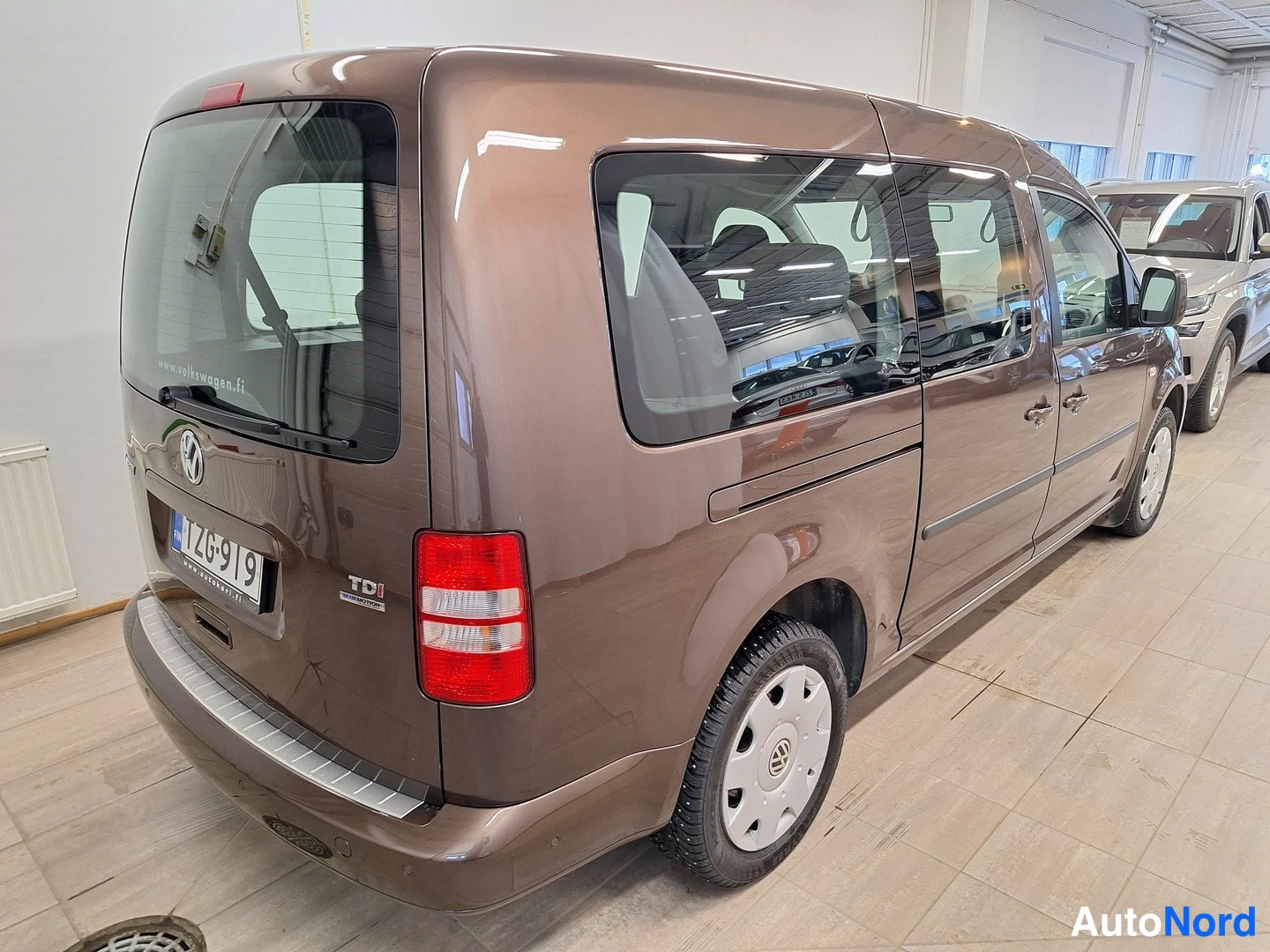 Takaviisto: Volkswagen Caddy, ruskea pakettiauto takakulmasta oikealle, TDI-merkintä takaluukussa
