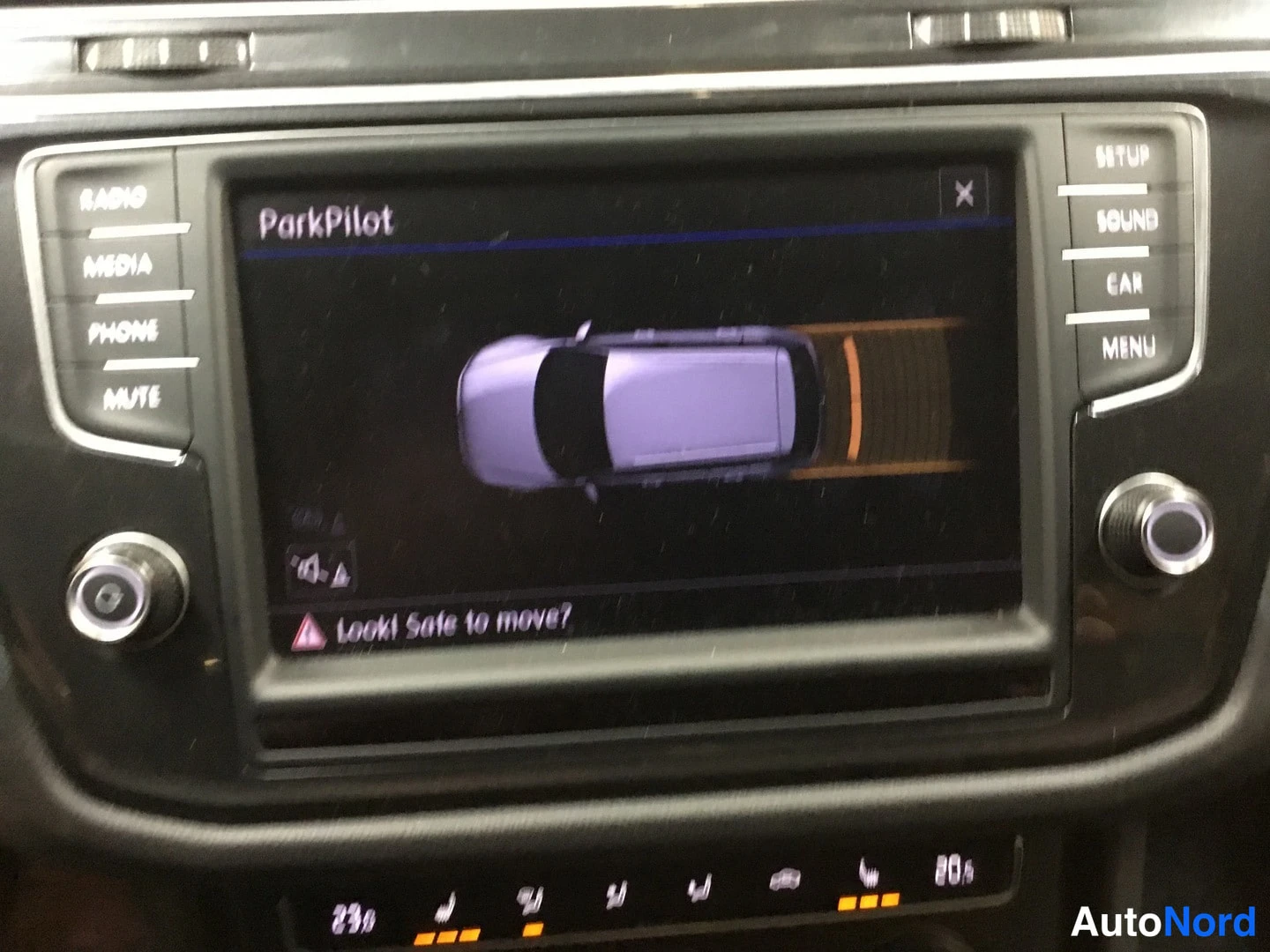 Muu: Infotainment-näyttö näyttää ParkPilot-törmäysvaroitusnäkymän auton ylhäältäpäin-kuvaan ja 'Looks! Safe to move?' -tekstiin.