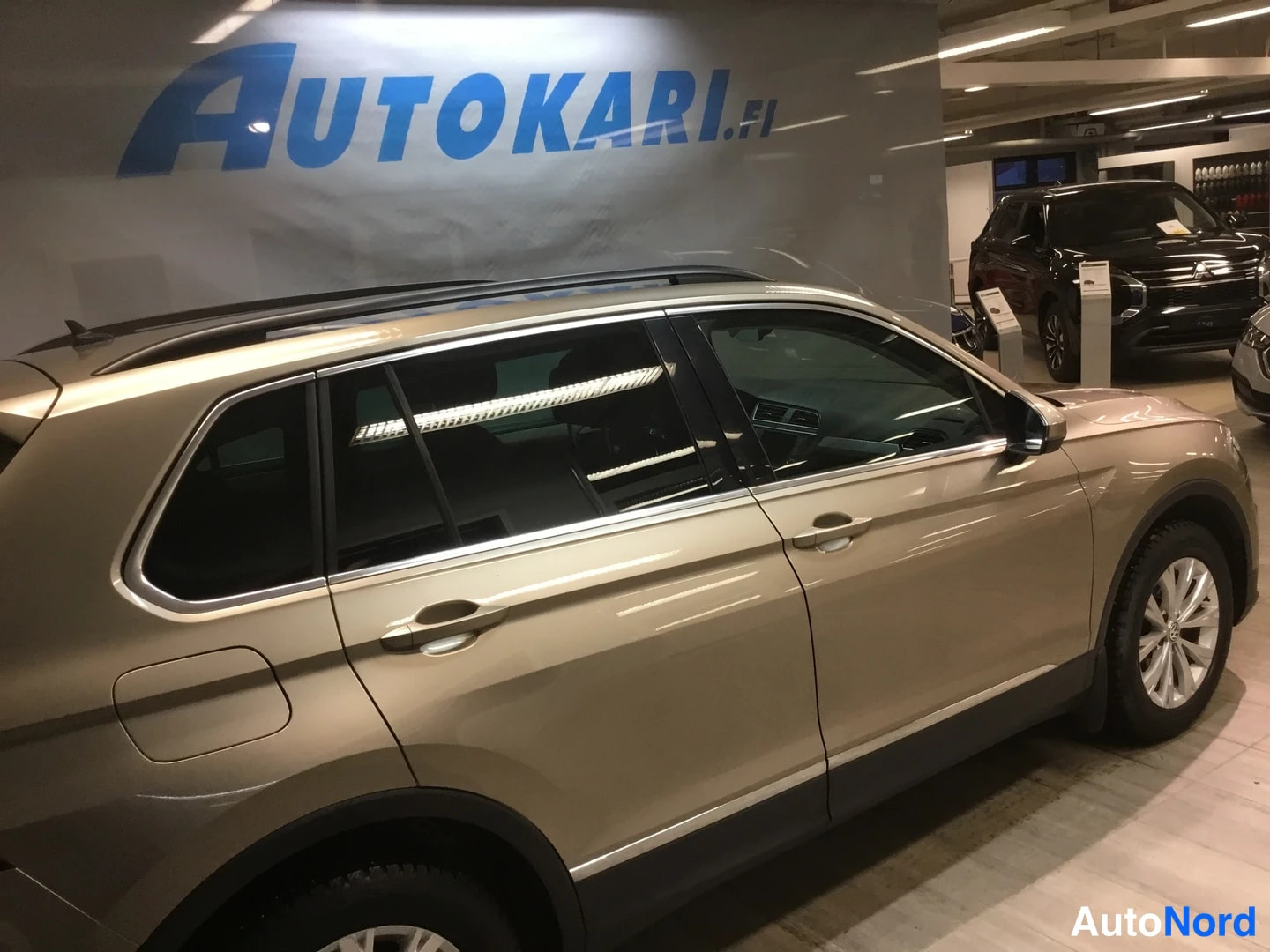 Sivulta: Volkswagen Tiguanin kylki sivulta, kultakeltaisen rungon takaosa