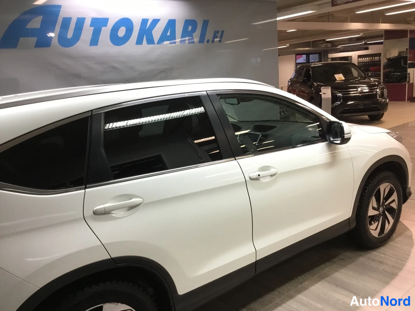 Sivulta: Valkoisen auton kylki näkyvissä sisätiloissa