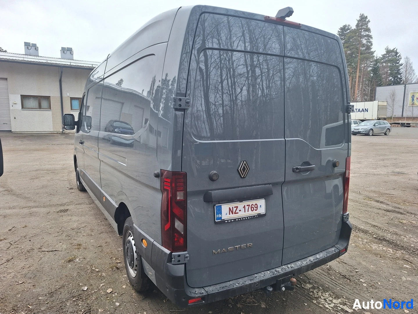 Takaviisto: Harmaan Renault Master -pakettiauton takaosa vasemmalta kuvattuna; rekisterikilpi NZ-1769 ja takaluukussa MASTER-teksti.