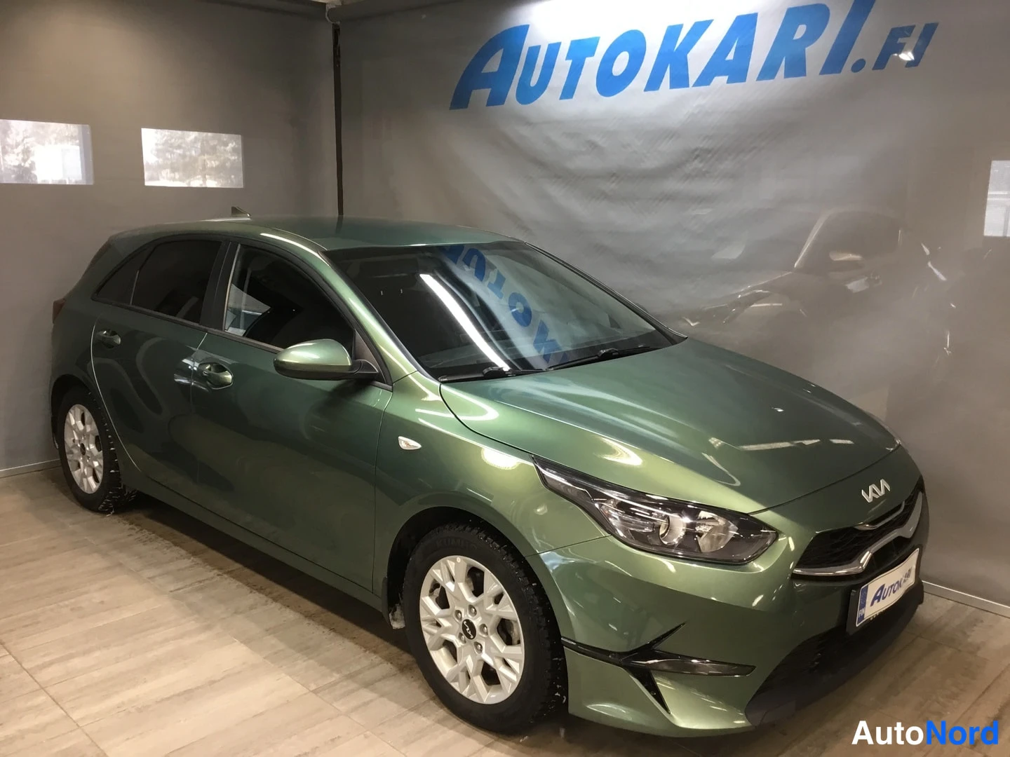 Etuviisto, nokka oikealle: Vihreä viistoperäinen henkilöauto etukulmasta, keula kuvan oikealla puolella.
