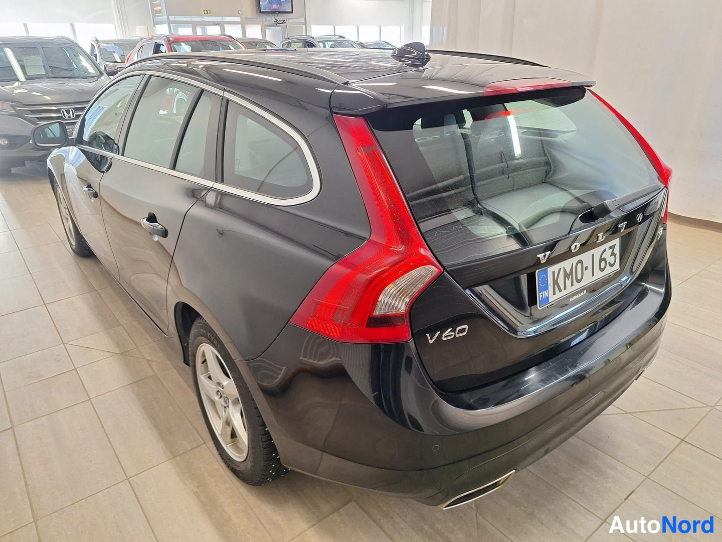 Takaviisto: Mustan Volvo V60:n takakolmannes­kulma; peräluukun V60-merkintä, rekisteritunnus KM0-163 ja vasemman kyljen ikkunat näkyvissä.