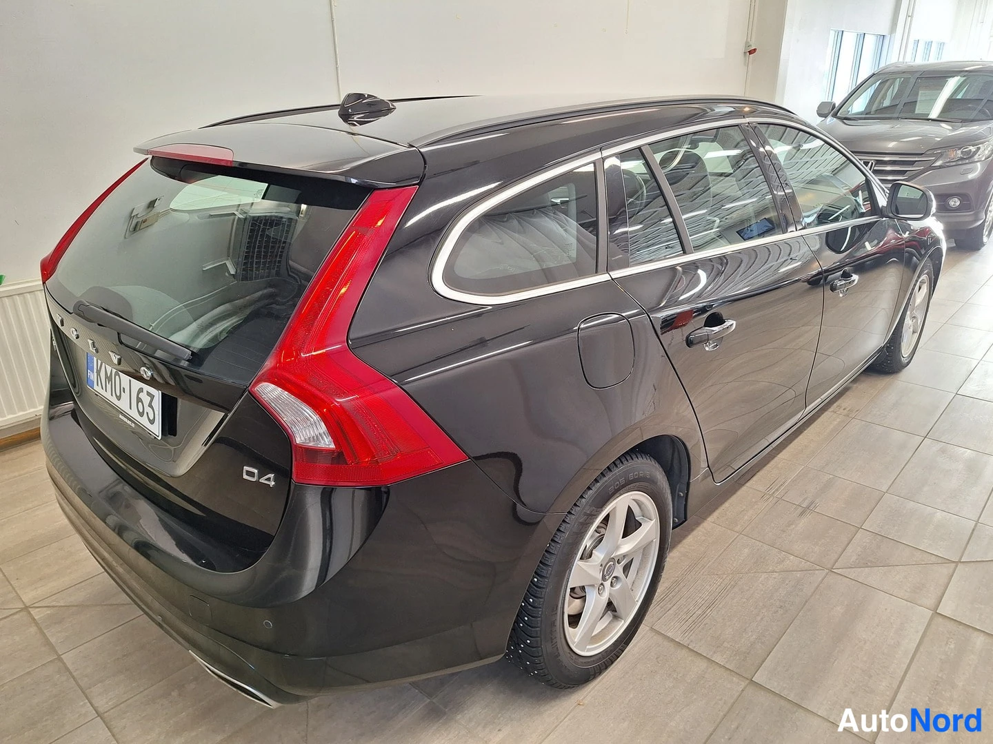 Takaviisto: Mustan Volvo V60:n takakolmannes­kulma; peräosassa D4-merkintä ja rekisteritunnus KM0-163, oikea kylki ja takapyörä näkyvissä.