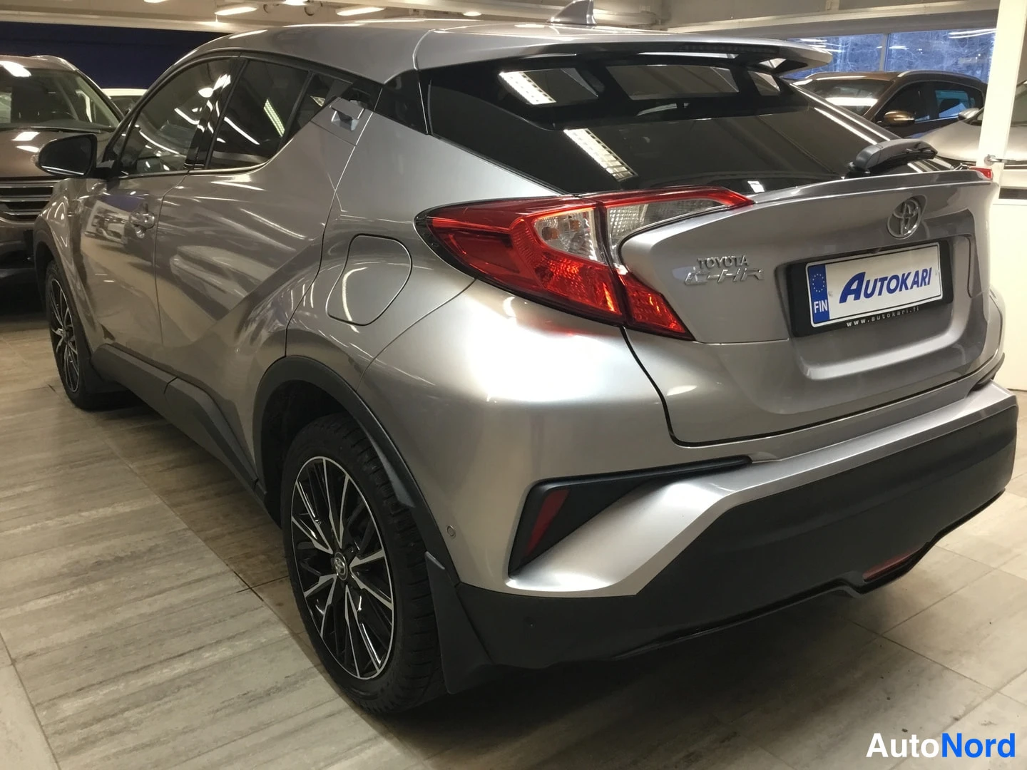 Takaviisto: Hopeanvärinen Toyota C-HR takaa kolmannesnäkymästä sisätiloissa.