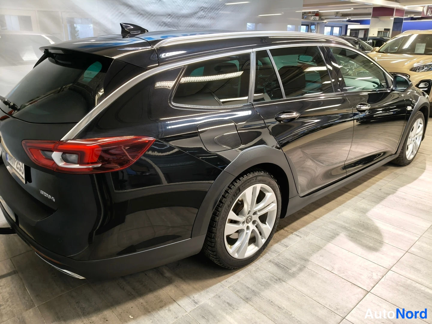Takaviisto: Musta Opel Insignia -farmaani takaviistosta: avattava takaluukku, kattohelistin, hopeavanteet ja mustat muovipaneelit.