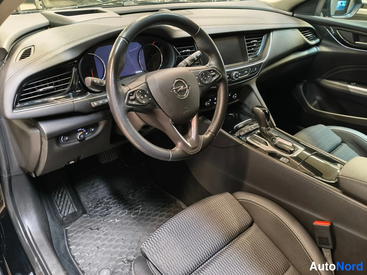 Muu: Opelin ohjaamo vasemmalta: monetitoimiohjauspyörä Opel-logolla, mittaristo, keskinäyttö ja automaattivaihteen valitsin.