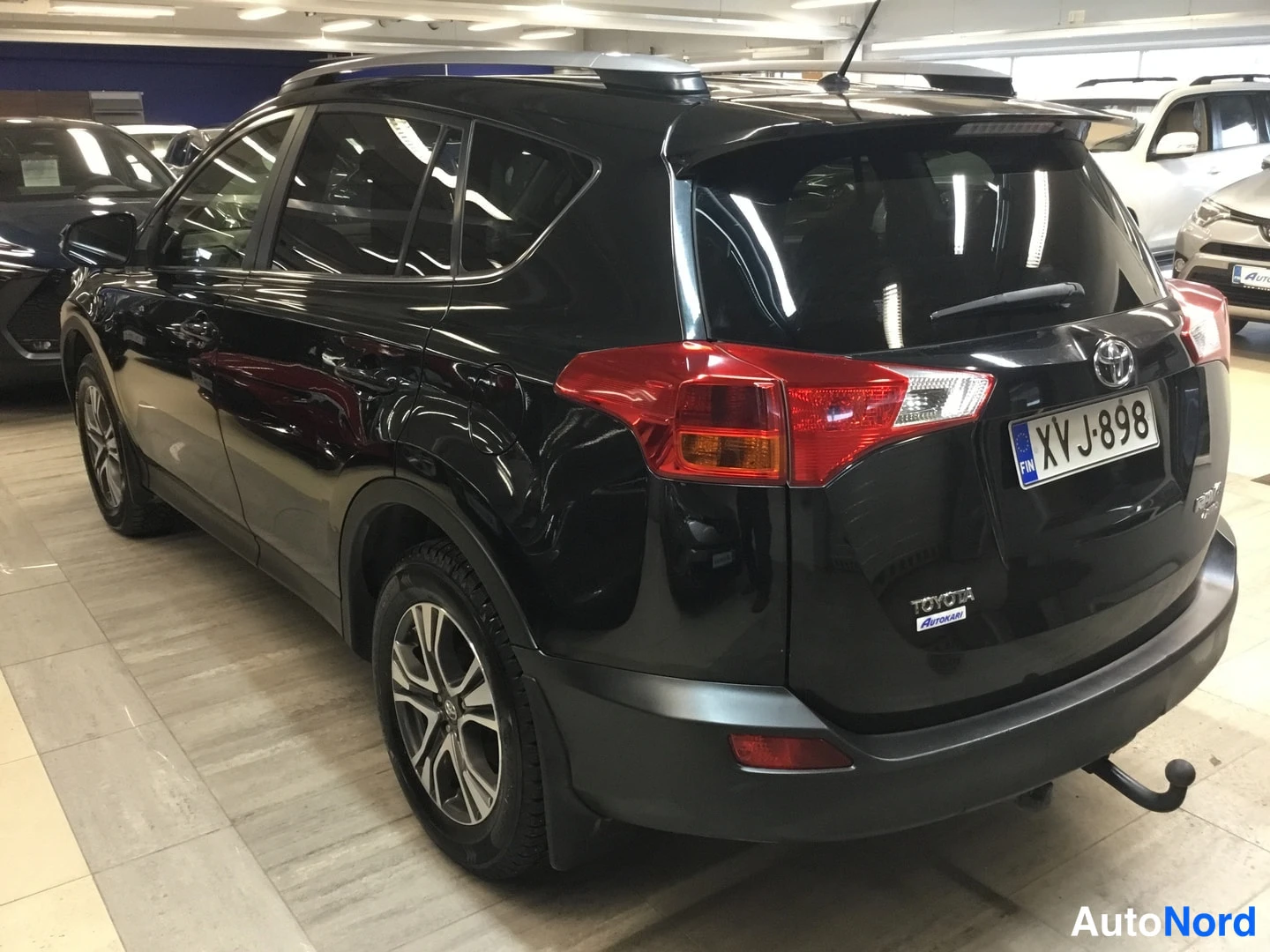 Takaviisto: Mustan Toyota RAV4 -maasturin takakulmanäyttö, rekisterikilpi ja Toyota-merkki näkyvät.