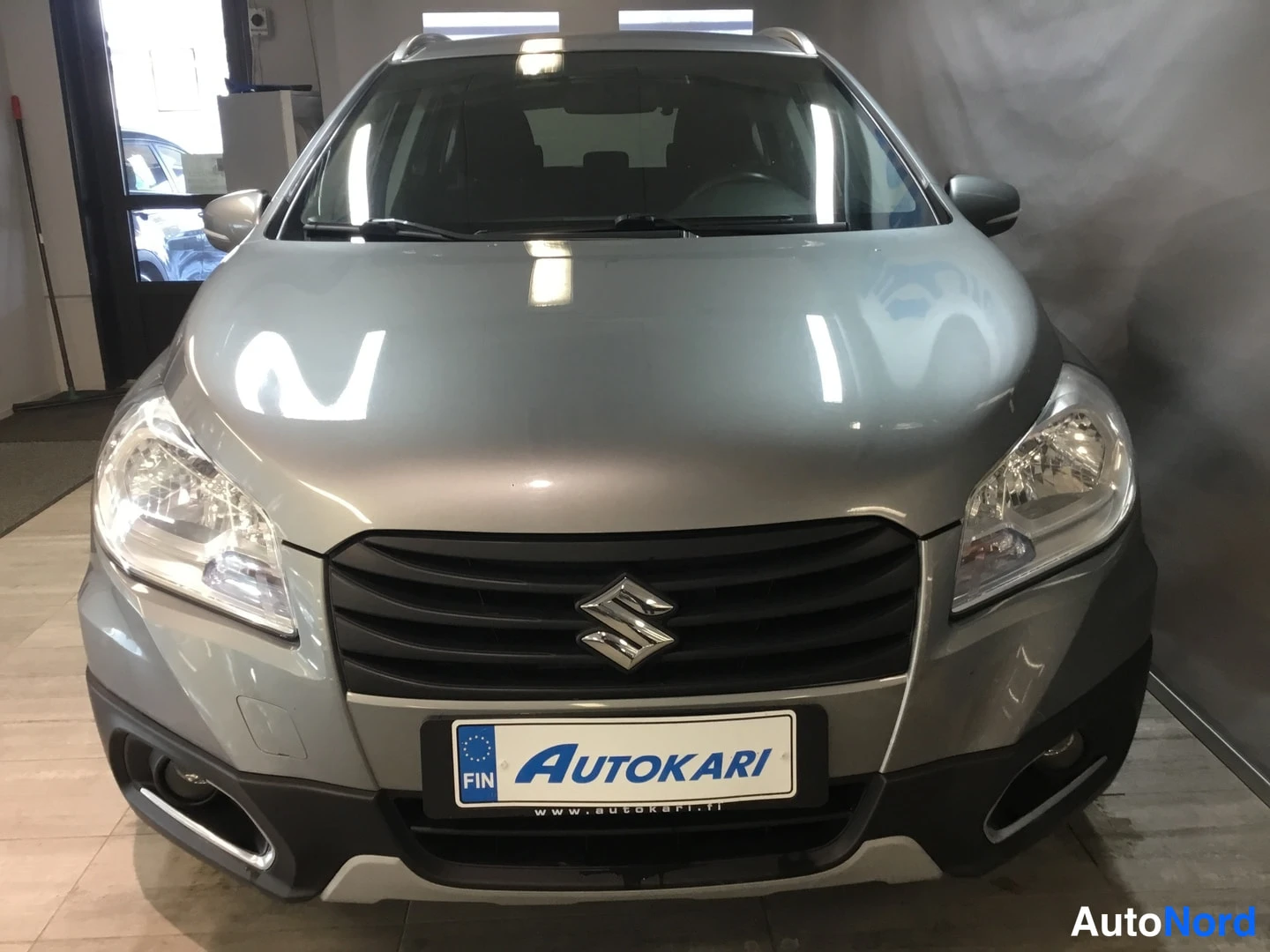 Edestä: Suzukin etupää edestä kuvattuna: sumutuskori, kohovalot ja Autokari-kilpi.