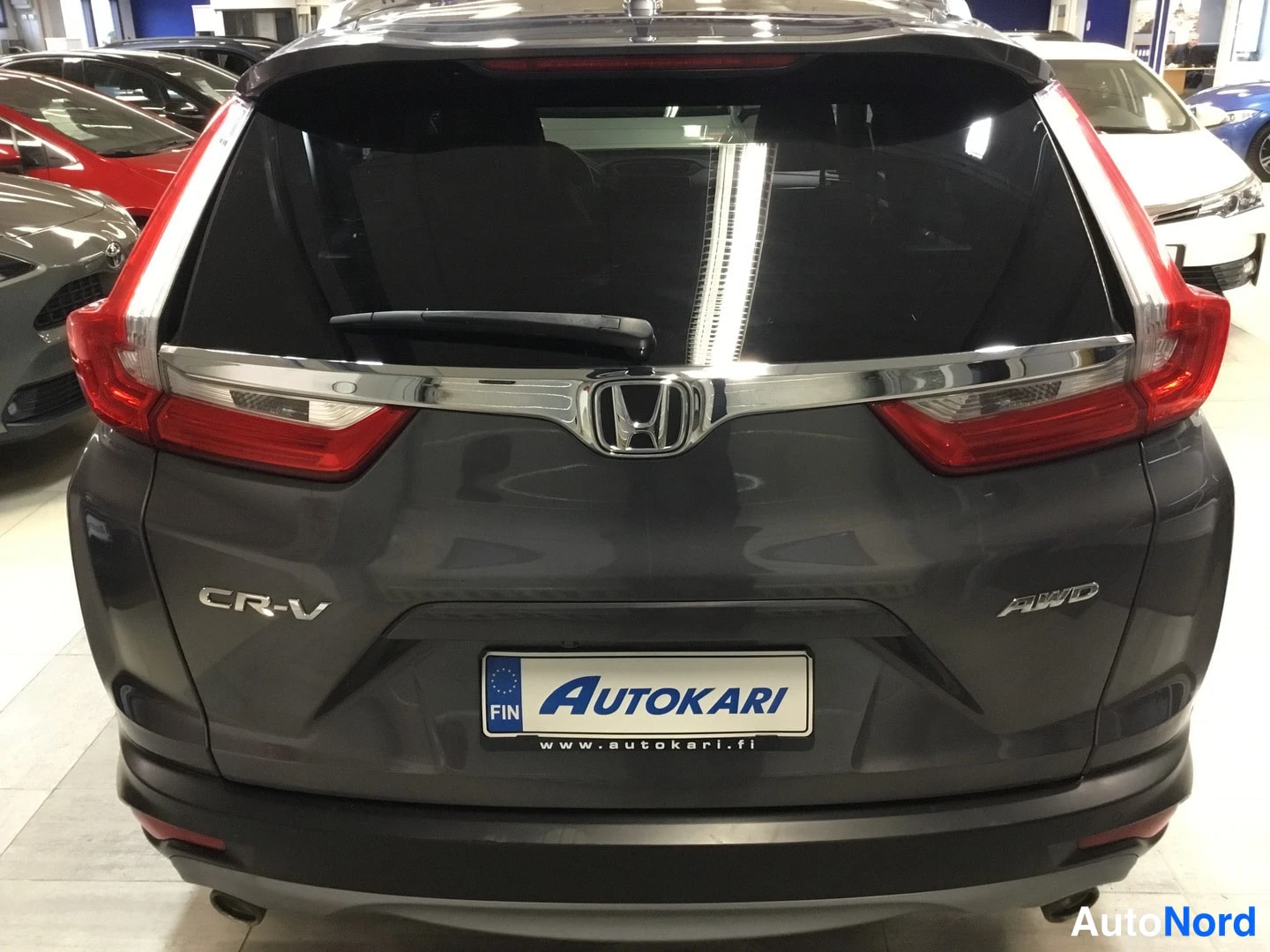 Takaa: Honda CR-V:n takanäkymä: CR-V- ja AWD-embleemit, kromilista ja Autokari-tunnus kilvessä.
