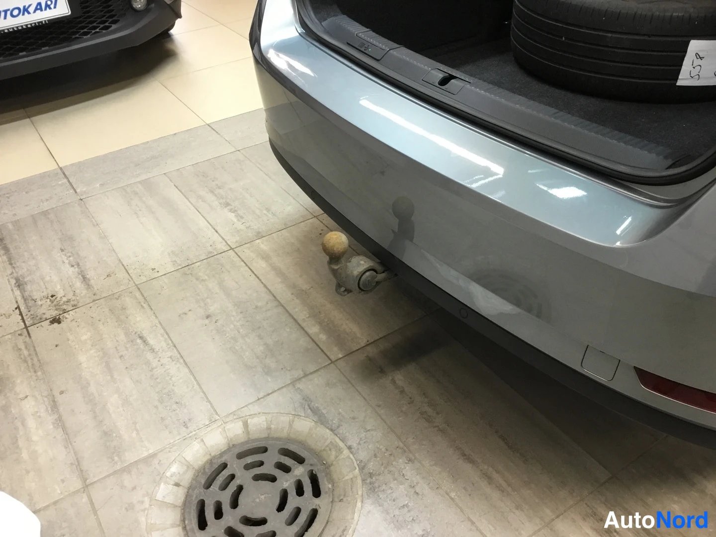 Takaa: Rear lower bumper area showing an attached tow bar and a parking sensor embedded in the bumper.