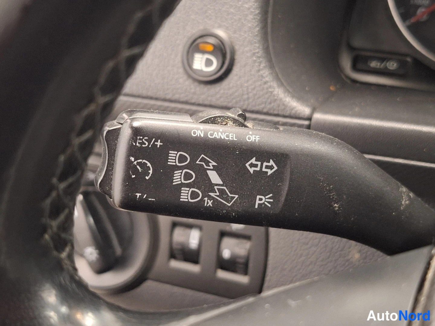 Ohjaamo: Oheislaitteiden ohjaustanko vasemmalla puolella rattiä; näkyvissä cruise control ja vilkkumerkit.