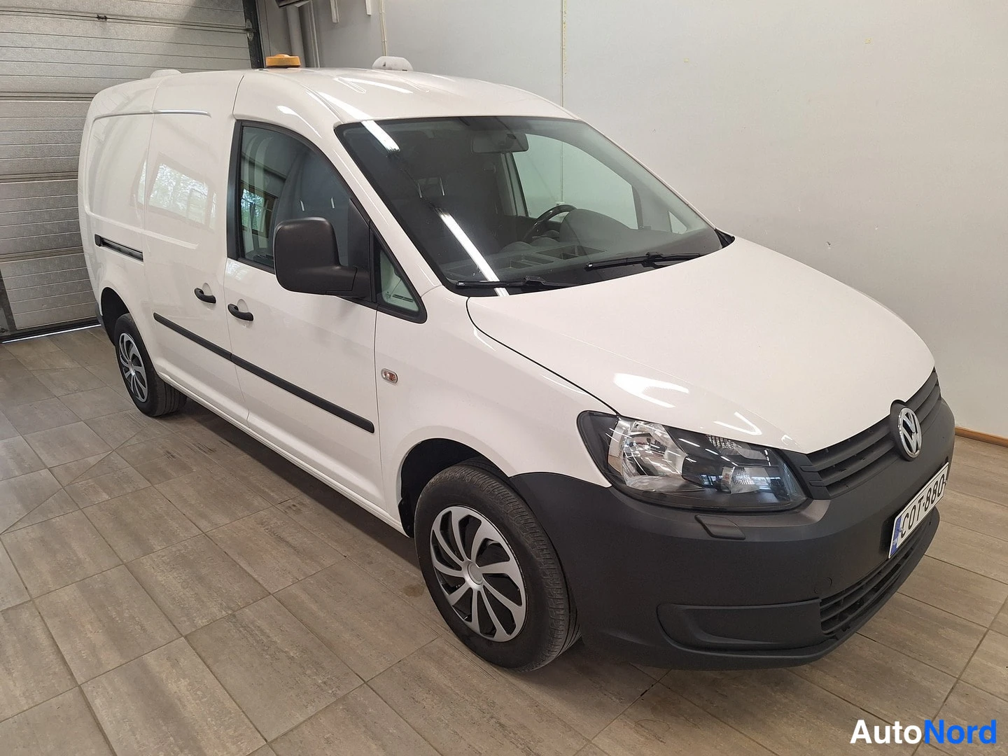 Etuviisto, nokka oikealle: Valkoinen pakettiauto (Volkswagen Caddy) sisätilassa
