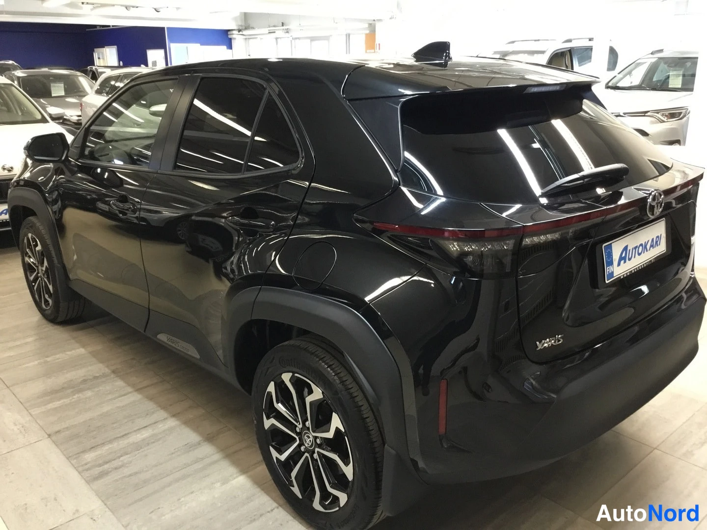 Takaviisto: Selkeä takakuva, jossa auton takana ja vasen puoli näkyvät kulmassa: taakkivalot, Toyota-logo, takavarasto ja rekisterikilven alue; koko auto osittain näkyvissä