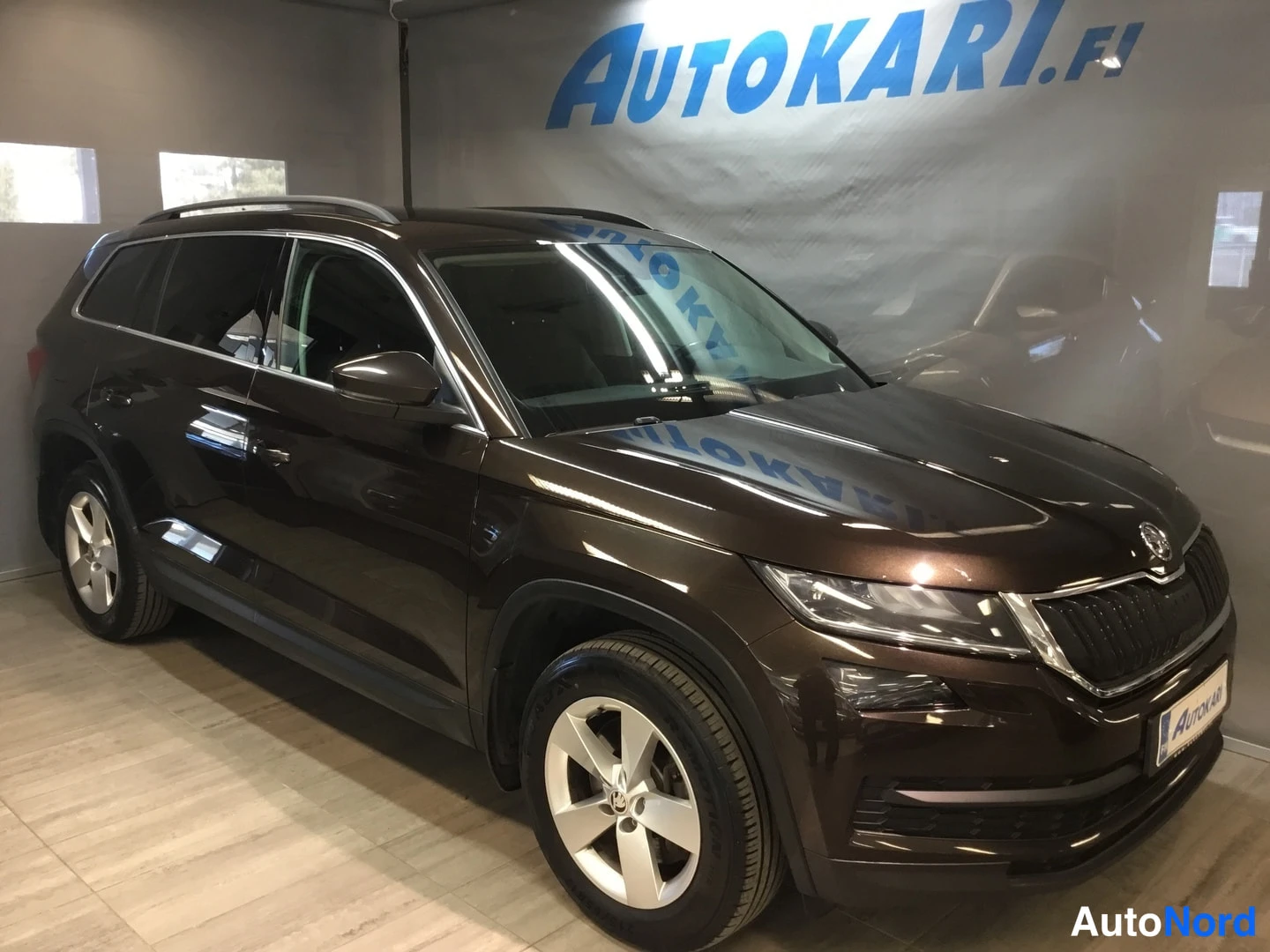 Etuviisto, nokka oikealle: Ruskean suklaanvärinen Skoda Kodiaq etukolmannelta oikealta autonäyttelytilassa.