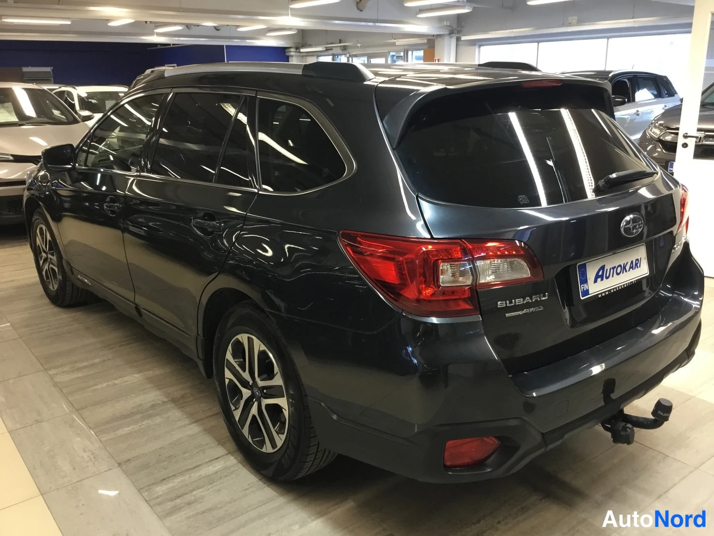 Takaviisto: Takaviisto vasemmalta tummanharmaasta Subaru Outbackista; takavalot, SUBARU-merkki ja vetokoukku näkyvät.