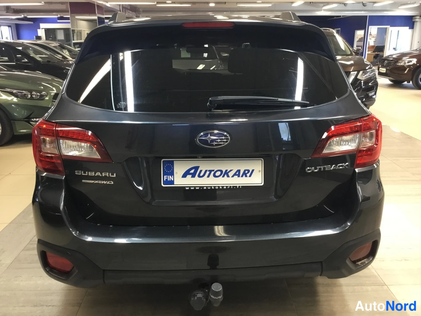 Takaa: Rear view of a dark Subaru Outback showing tail lights and tow bar