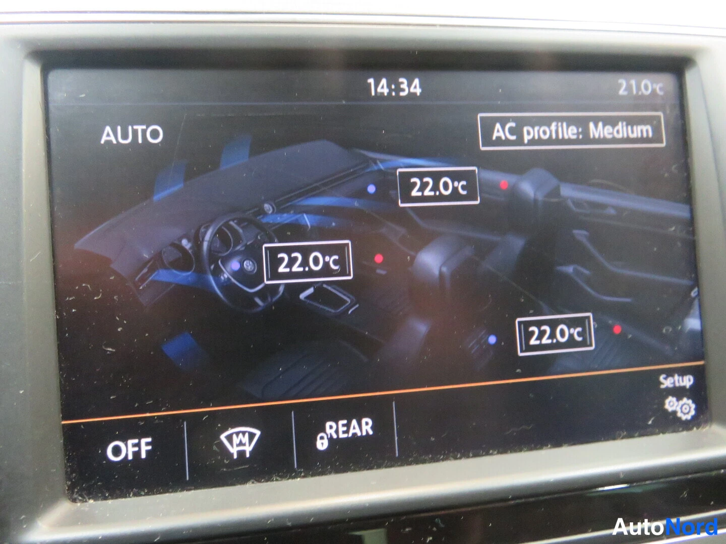 Yksityiskohta: Infonäytön ilmastointivalikko näyttää AUTO-tilan, lämpötilaksi 22,0 °C ja AC-profiiliksi Medium.