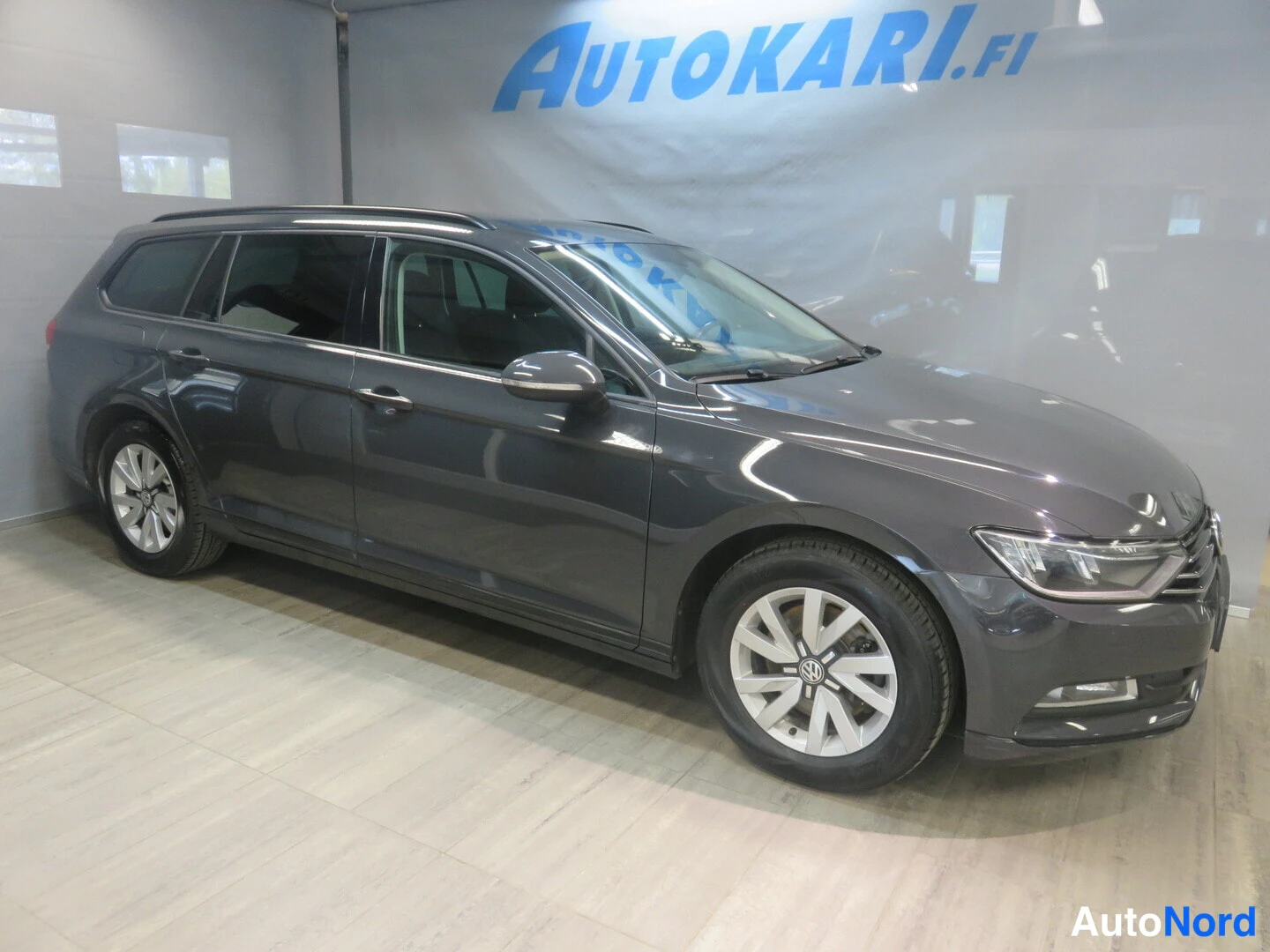 Etuviisto, nokka oikealle: Tummanharmaa farmariauto kuvattu kulmasta, keula oikealla