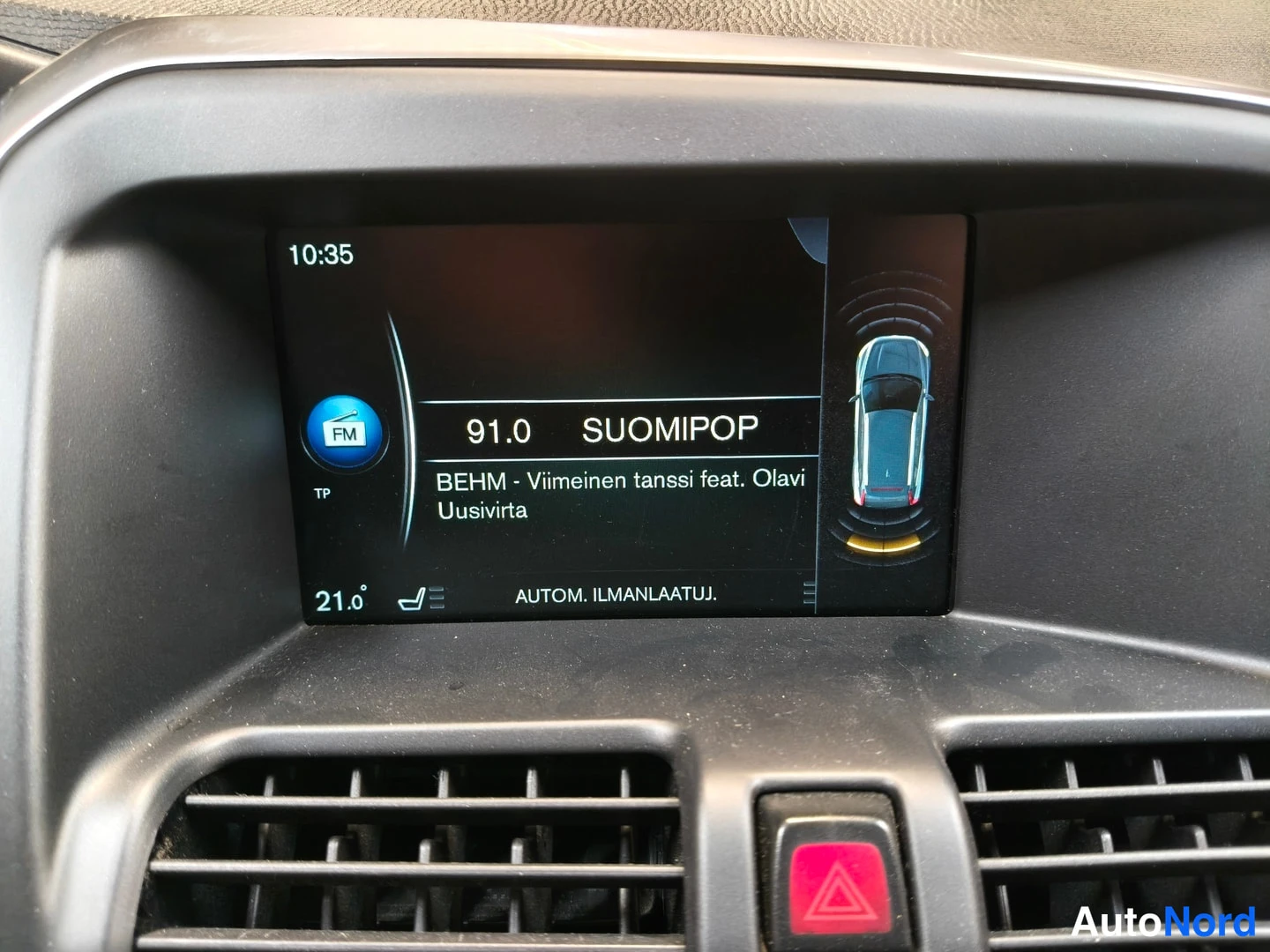 Muu: Autoradion näyttö näyttää kanavan 91.0 SUOMIPOP, kellonajan 10:35 ja lämpötilan 21,0 astetta.